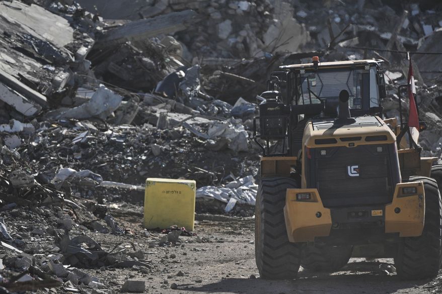 A yellow block demarcating the "Yellow Line," which has separated the Gaza Strip's Israeli-held and Palestinian zones since the October ceasefire, is visible in Jabalia, northern Gaza Strip. where Hamas militants are searching for the remains of hostages, Monday, Dec. 1, 2025. (AP Photo/Jehad Alshrafi)