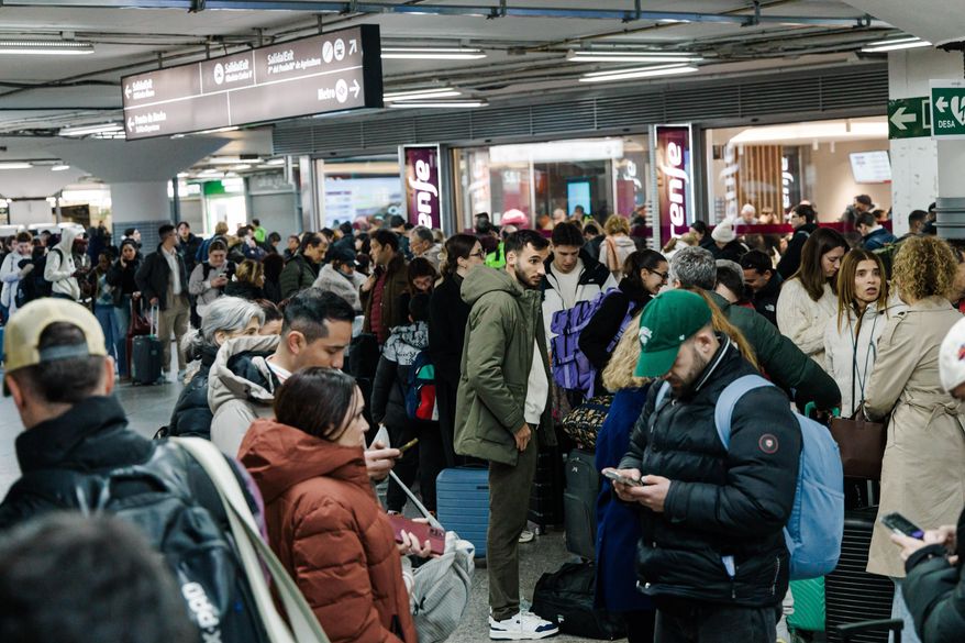 Passengers wait in the hall of Madrid train station on Sunday, January 18, 2026, following the announcement of the suspension of service due to an accident in which two trains derailed in Cordoba. ( Carlos Luján/Europa Press via AP)