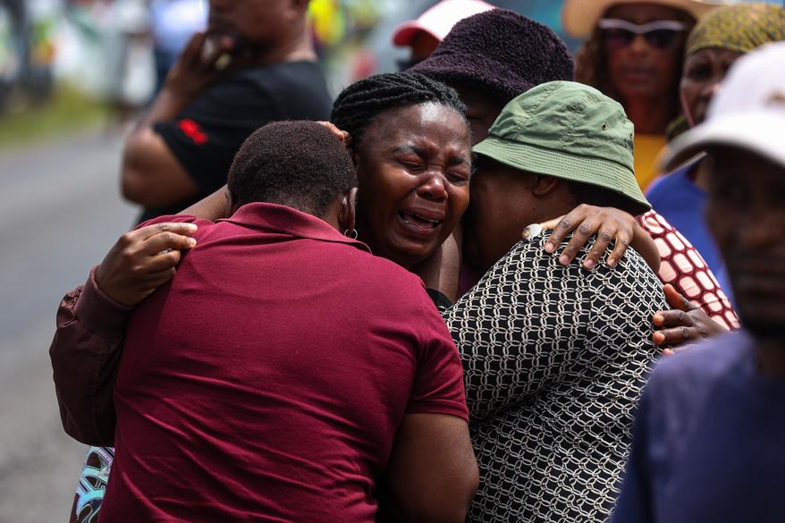 Relatives of school children who died when the minibus they were riding in collided with a truck, weep at the scene of the crash in Vanderbijlpark, South of Johannesburg, South Africa, Monday, Jan. 19, 2026. (AP Photo)