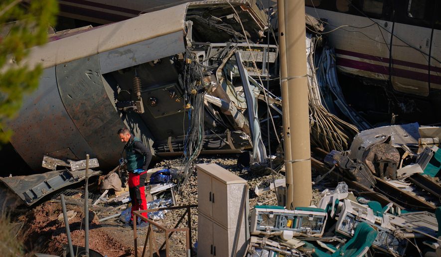Guardia Civil officers collect evidence next to the wreckage of train cars involved in a collision in Adamuz, southern Spain, Tuesday, Jan. 20, 2026. (AP Photo/Manu Fernandez)