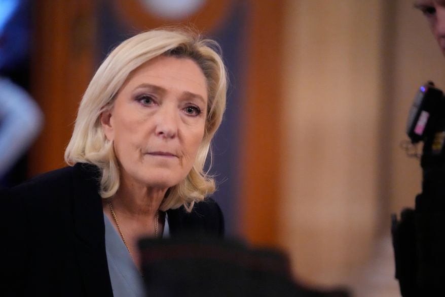 Far-right leader Marine Le Pen, left, walks outside the courtroom during a short break in her appeals trial in Paris, Tuesday, Jan. 20, 2026. (AP Photo/Michel Euler)