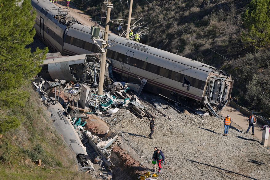 Guardia Civil officers collect evidence next to the wreckage of train cars involved in a collision in Adamuz, southern Spain, Tuesday, Jan. 20, 2026. (AP Photo/Manu Fernandez)