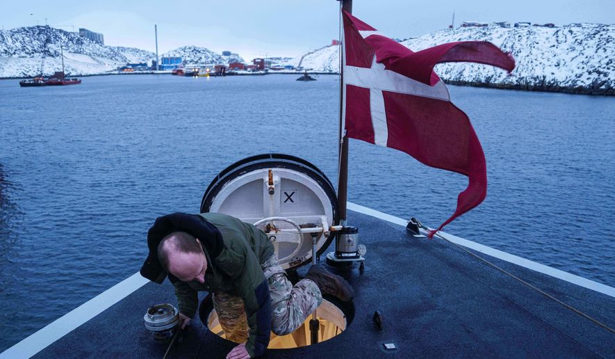 A Danish serviceman climbs out of a hatch on the bow of the military vessel HDMS Knud Rasmussen of the Royal Danish Navy docked in Nuuk, Greenland, on Saturday, Jan. 17, 2026. (AP Photo/Evgeniy Maloletka)