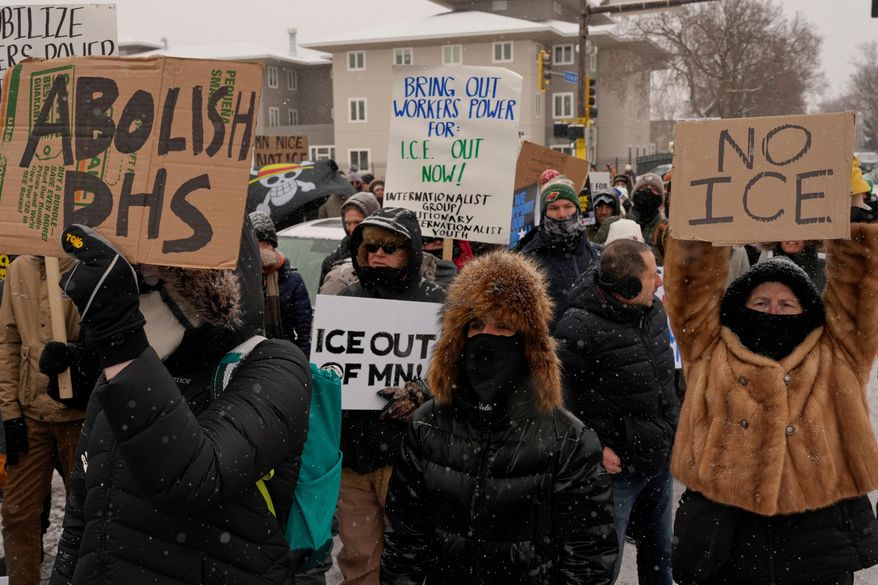 People gather near the post office during a protest, Sunday, Jan. 18, 2026, in Minneapolis. (AP Photo/Yuki Iwamura)