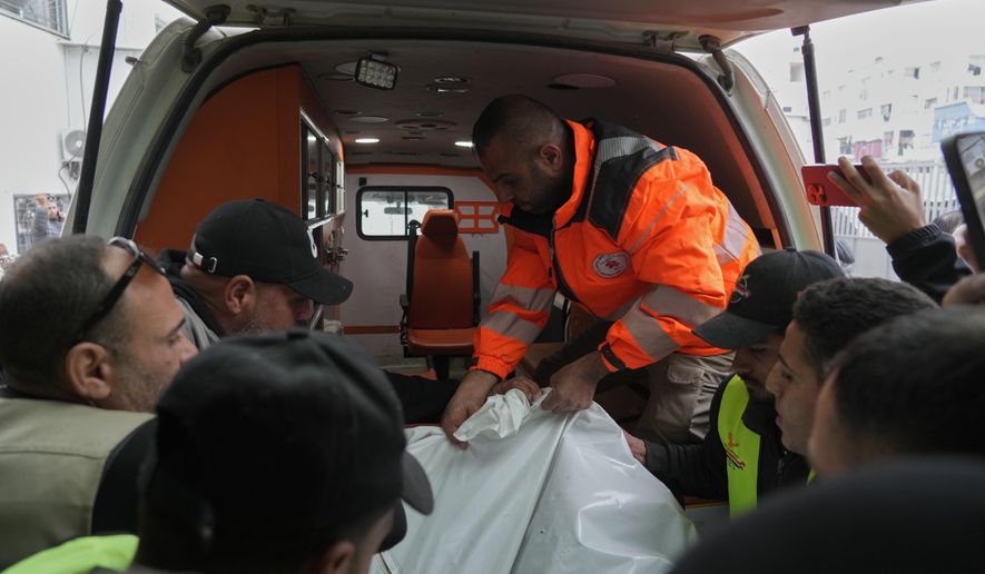 People carry a bag containing the bodies of the Palestinian journalists Abd Shaat and Mohamed Qeshta, who were killed in an Israeli strike on a vehicle, before their funeral at Shifa Hospital, in Gaza City, Wednesday, Jan. 21, 2026. (AP Photo/Jehad Alshrafi)