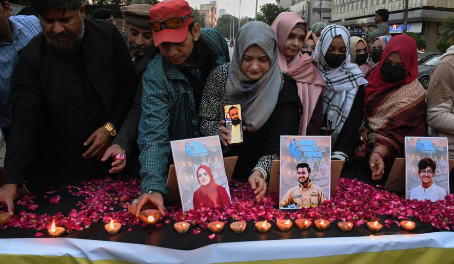 People take part in a candle light vigil for the victims of shopping mall fire incident, in Karachi, Pakistan, Wednesday, Jan. 21, 2026. (AP Photo/Ali Raza)
