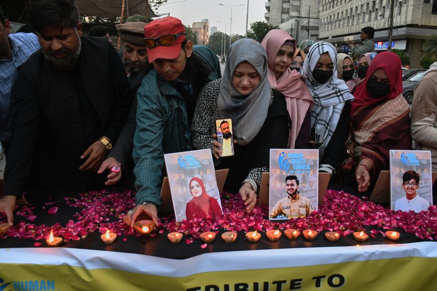 People take part in a candle light vigil for the victims of shopping mall fire incident, in Karachi, Pakistan, Wednesday, Jan. 21, 2026. (AP Photo/Ali Raza)