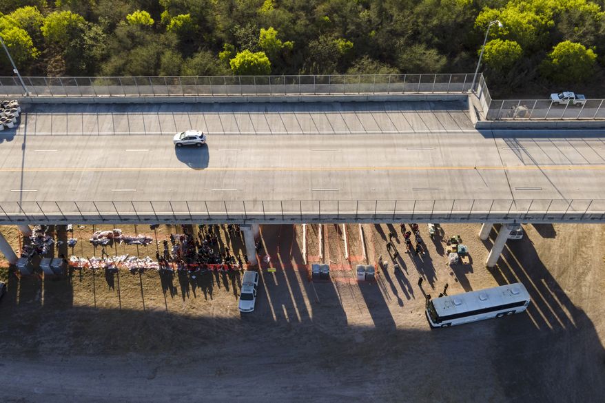 In this photo taken by a drone, migrants are seen in custody at a U.S. Customs and Border Protection processing area under the Anzalduas International Bridge in Mission, Texas, on Thursday, March 18, 2021. (AP Photo/Julio Cortez) **FILE**
