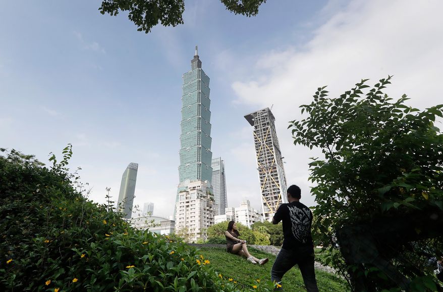 People take photos with the iconic Taipei 101 skyscraper in the background in Taipei, Taiwan, April 27, 2025. (AP Photo/Chiang Ying-ying, File)
