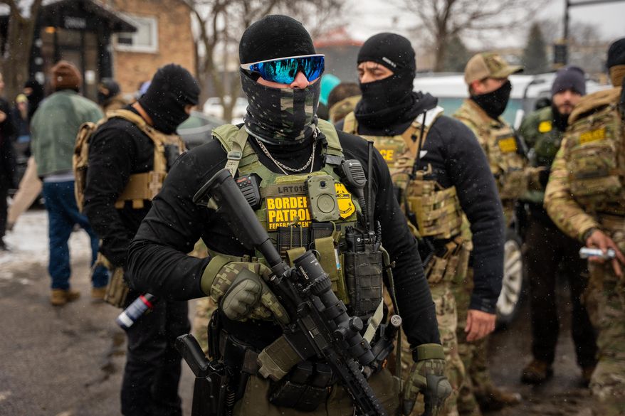 Federal agents stand guard, Wednesday, Jan. 21, 2026, in Minneapolis. (AP Photo/Angelina Katsanis)