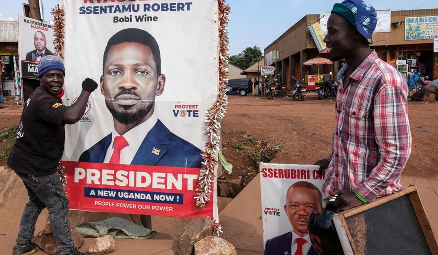 A supporter of Uganda opposition presidential candidate Robert Kyagulanyi Ssentamu, known as Bobi Wine, holds onto a campaign poster in Kampala, Uganda, Tuesday, Jan. 13, 2026. (AP Photo/Hajarah Nalwadda)