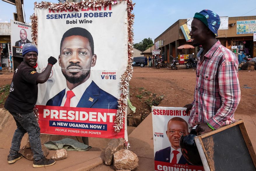 A supporter of Uganda opposition presidential candidate Robert Kyagulanyi Ssentamu, known as Bobi Wine, holds onto a campaign poster in Kampala, Uganda, Tuesday, Jan. 13, 2026. (AP Photo/Hajarah Nalwadda)