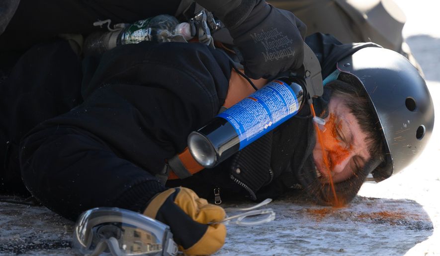 A protester is pepper sprayed at close range while being detained near the site of the fatal shooting of 37-year-old Alex Pretti by federal agents in Minneapolis on Saturday, Jan. 24, 2026. (Ellen Schmidt/MinnPost via AP)