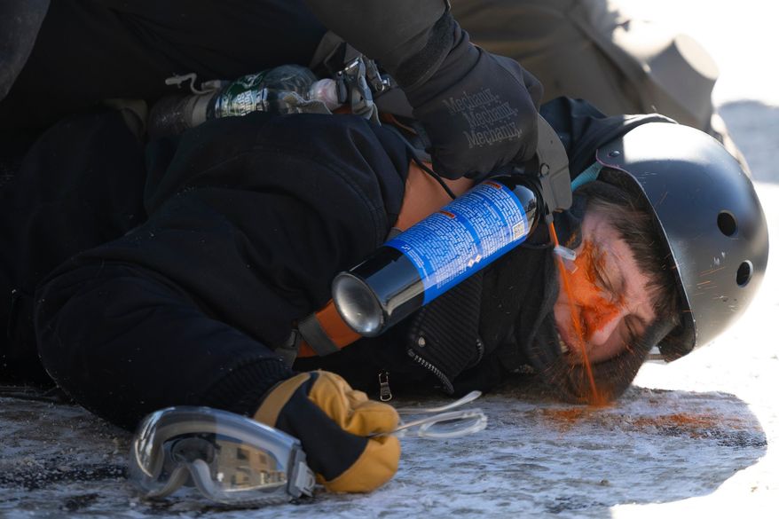 A protester is pepper sprayed at close range while being detained near the site of the fatal shooting of 37-year-old Alex Pretti by federal agents in Minneapolis on Saturday, Jan. 24, 2026. (Ellen Schmidt/MinnPost via AP)
