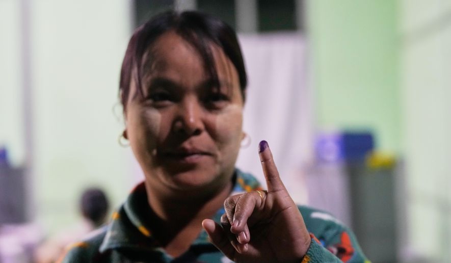 A voter holds up her finger marked with ink indicating she voted at a polling station during the third phase of general election in Mandalay, central Myanmar, Sunday, Jan. 25, 2026. (AP Photo/Aung Shine Oo)
