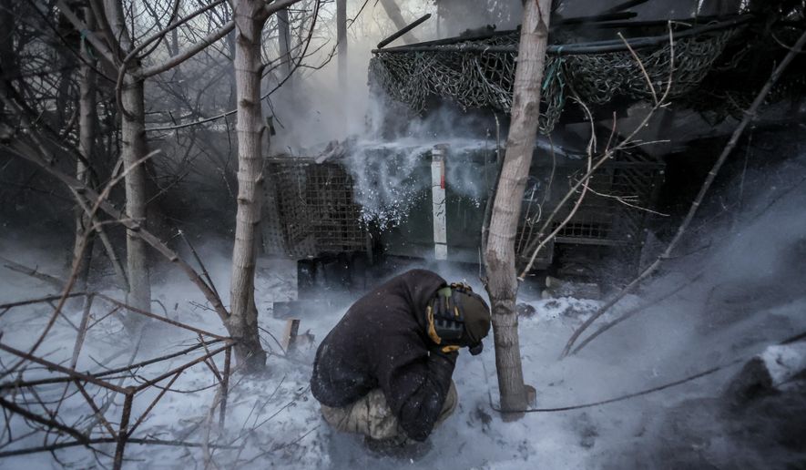 In this photo provided by Ukraine's 24th Mechanized Brigade press service, servicemen fire a 2S1 Gvozdika self propelled howitzer towards Russian positions near Chasiv Yar town, Donetsk region, Ukraine, Sunday, Jan. 18, 2026. (Oleg Petrasiuk/Ukraine's 24th Mechanized Brigade via AP)