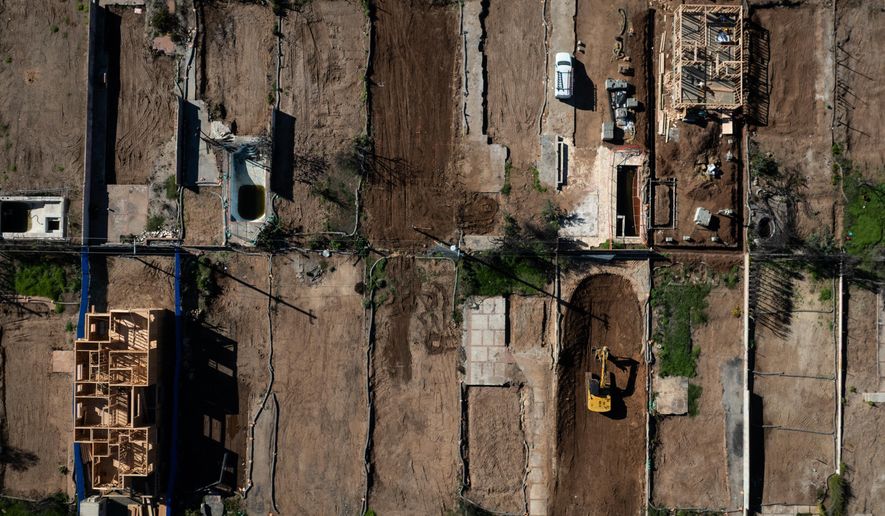 FILE - An aerial view shows houses being rebuilt on cleared lots months after the Palisades Fire, Dec. 5, 2025, in the Pacific Palisades neighborhood of Los Angeles. (AP Photo/Jae C. Hong, File)