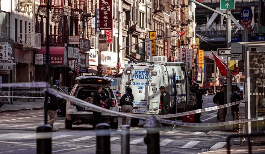 New York Police Department officers investigate the scene of an attack in Manhattan's Chinatown neighborhood, Oct. 5, 2019, in New York. (AP Photo/Jeenah Moon, File)
