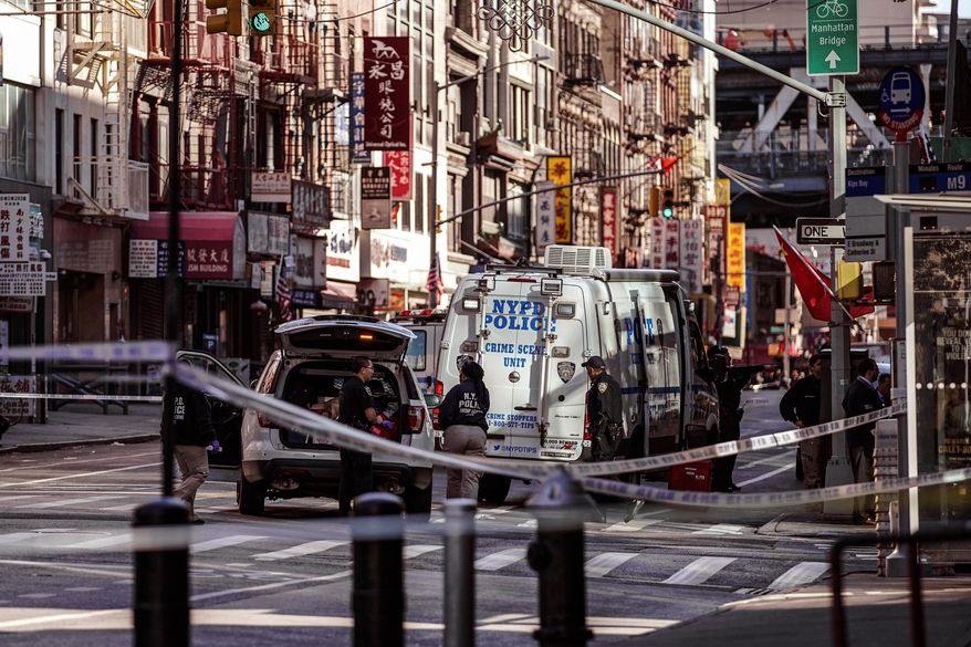 New York Police Department officers investigate the scene of an attack in Manhattan's Chinatown neighborhood, Oct. 5, 2019, in New York. (AP Photo/Jeenah Moon, File)