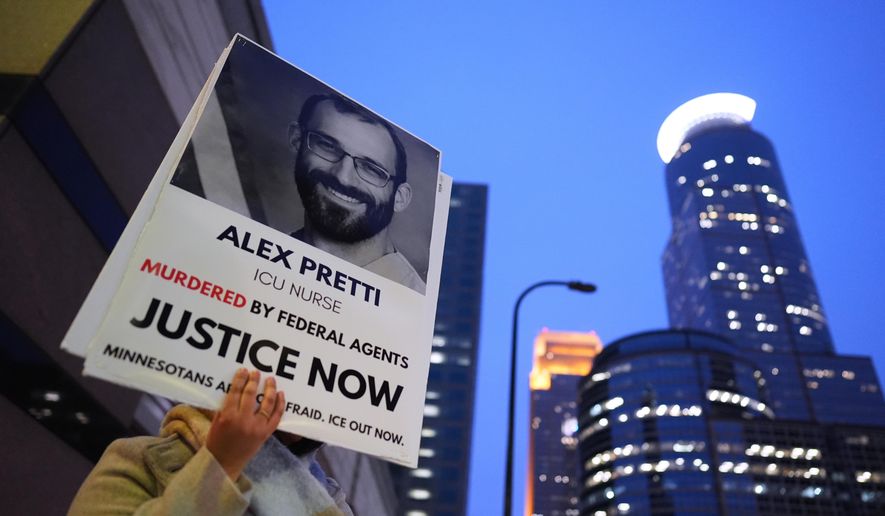 A person holds a sign of Alex Pretti during a protest outside the office of Sen. Amy Klobuchar, D-Minn., on Monday, Jan. 26, 2026, in Minneapolis. (AP Photo/Adam Gray)