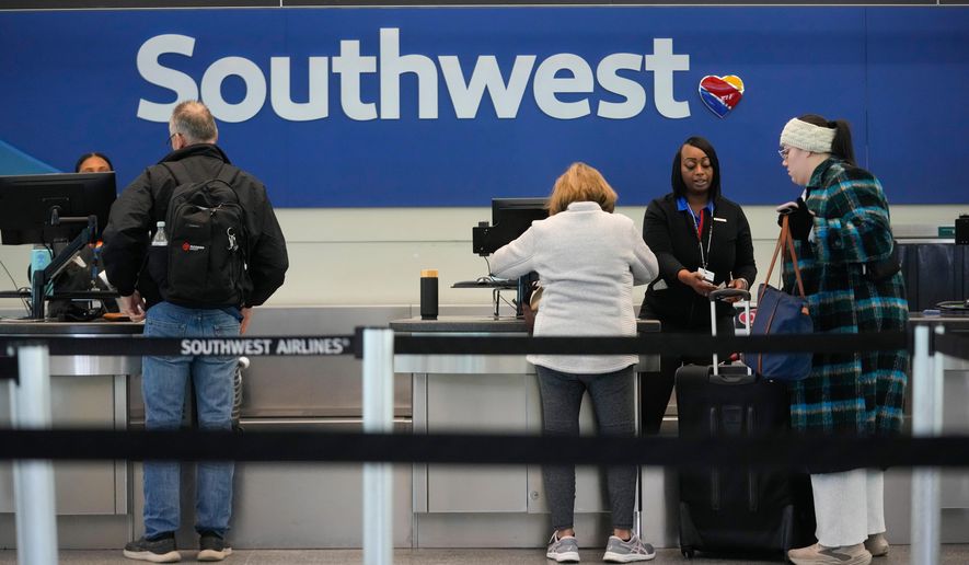Travelers check in with Southwest Airlines at Midway International Airport, Tuesday, Jan. 27, 2026, in Chicago. (AP Photo/Erin Hooley)