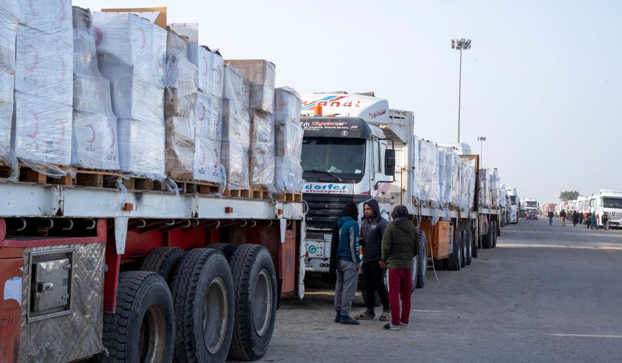 Trucks line up to enter the Egyptian gate of the Rafah crossing, heading for inspection by Israeli authorities before entering the Gaza Strip, Tuesday, Jan.27, 2026. (AP Photo/Mohamed Arafat)