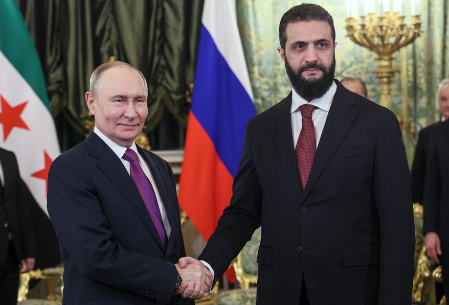 Russian President Vladimir Putin, left, and Syrian interim President Ahmad al-Sharaa pose for a photo during their meeting at the Grand Kremlin Palace in Moscow, on Wednesday, Jan. 28, 2026. (Maxim Shipenkov/Pool Photo via AP)