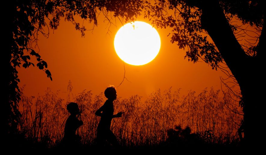 People are silhouetted against the sky at sunset as they run at Shawnee Mission Park in Shawnee, Kan., on Sept. 26, 2024. (AP Photo/Charlie Riedel) **FILE**