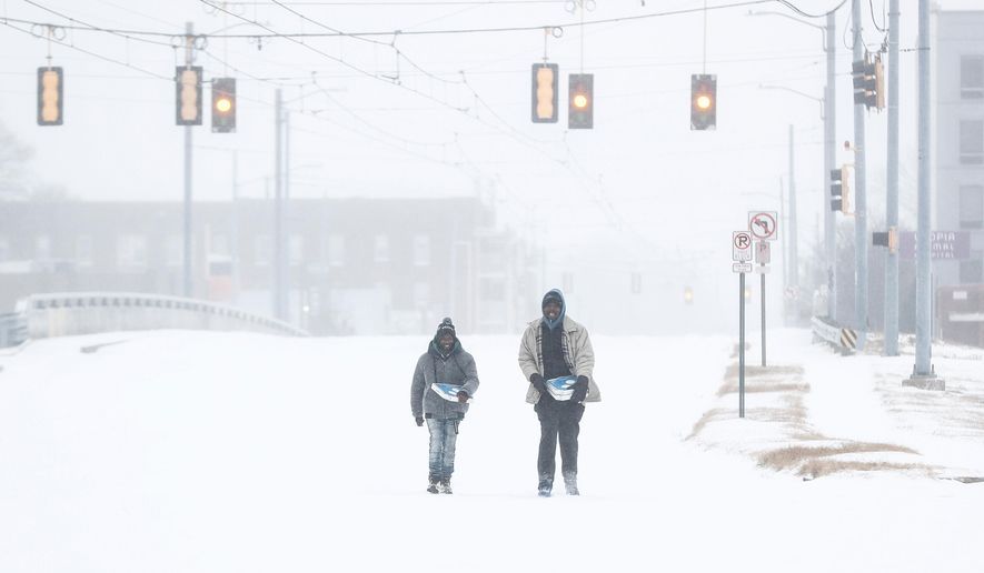 Jimmy Jordan, left, and Cordarol Dale walk through snow in Memphis, Tenn., Saturday, Jan. 24, 2026. (Mark Weber/Daily Memphian via AP)
