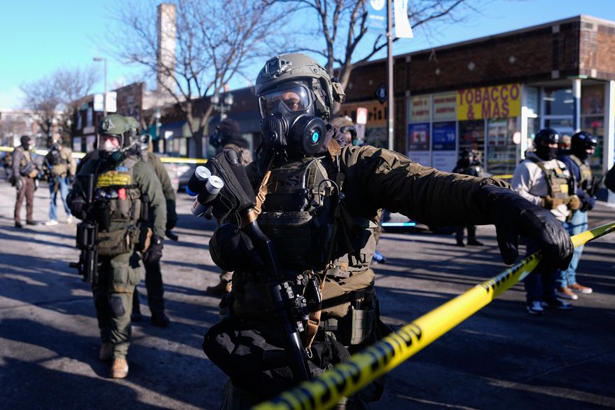Federal agents stand near the site of a shooting Saturday, Jan. 24, 2026, in Minneapolis. (AP Photo/Abbie Parr)