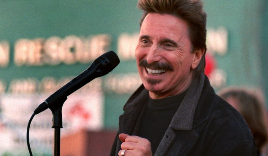 Chuck Negron, former lead singer of Three Dog Night, sings to a crowd during a Christmas Eve party Wednesday, Dec. 24, 1997, at the Union Rescue Mission in Los Angeles. More than 3,000 homeless and poor were treated to food, toys and entertainment in the Skid Row community. (AP Photo/John Hayes)