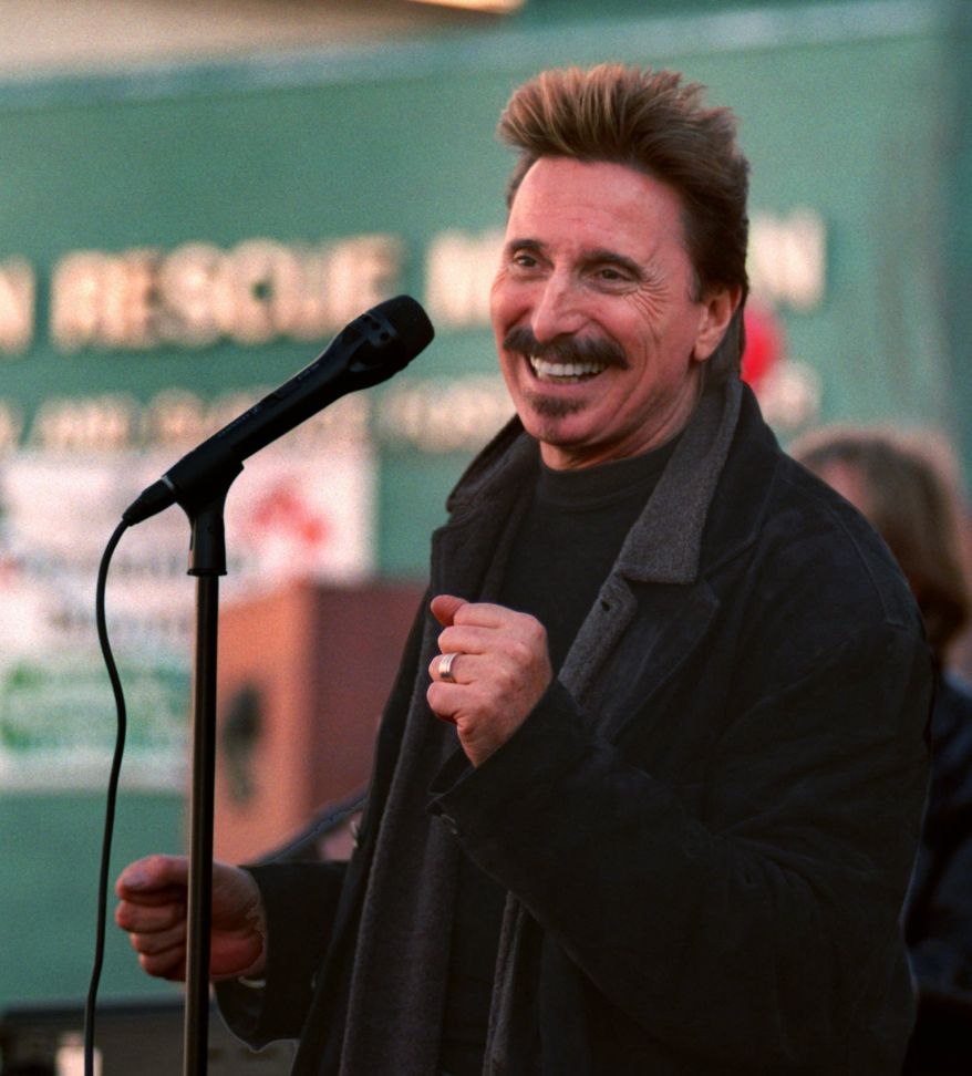 Chuck Negron, former lead singer of Three Dog Night, sings to a crowd during a Christmas Eve party Wednesday, Dec. 24, 1997, at the Union Rescue Mission in Los Angeles. More than 3,000 homeless and poor were treated to food, toys and entertainment in the Skid Row community. (AP Photo/John Hayes)