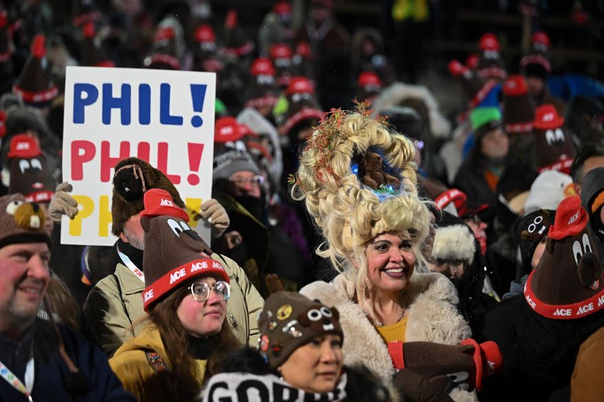 Toni Massey, of Bismack, N.D., right, celebrates while waiting for Punxsutawney Phil, the weather prognosticating groundhog, to come out and make his prediction during the 140th celebration of Groundhog Day on Gobbler's Knob in Punxsutawney, Pa., Monday, Feb. 2, 2026. (AP Photo/Barry Reeger)