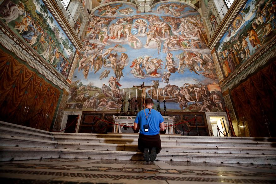 A visitor kneels in front of the Last Judgement fresco by the Italian Renaissance painter Michelangelo inside the Sistine Chapel in Rome, May 3, 2021. (AP Photo/Alessandra Tarantino, File)