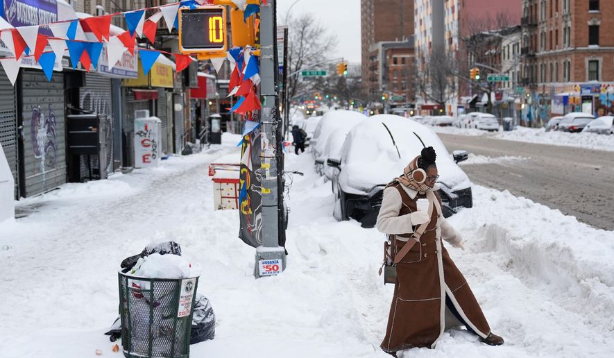 FILE - Carrie Hampton tries to navigate a snowy intersection without spilling her coffee in New York, Jan. 26, 2026. (AP Photo/Seth Wenig, File)