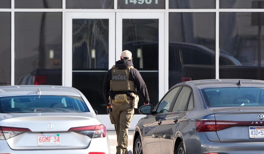 An ICE agent stands outside a warehouse as federal officials tour the facility to consider repurposing it as an ICE detention facility, Thursday, Jan. 15, 2026, in Kansas City, Mo. (AP Photo/Charlie Riedel)