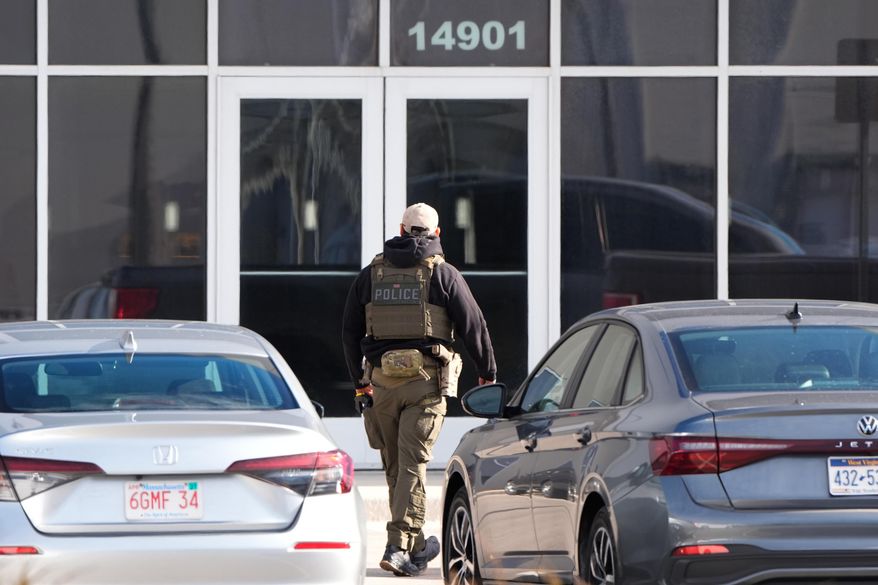 An ICE agent stands outside a warehouse as federal officials tour the facility to consider repurposing it as an ICE detention facility, Thursday, Jan. 15, 2026, in Kansas City, Mo. (AP Photo/Charlie Riedel)