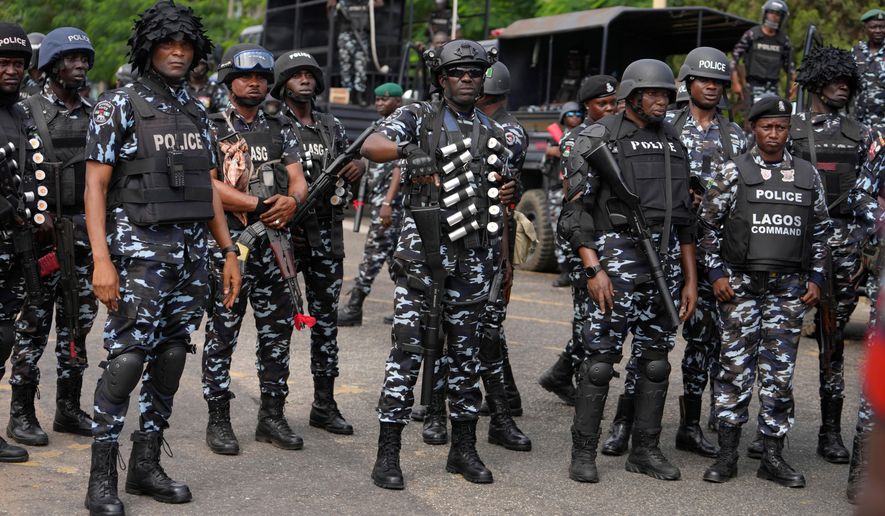 FILE - Nigeria police officers stand guard during a candle light procession in honour of all protesters killed nationwide at the recently economic hardship protest, in Lagos, Nigeria, Friday, Aug. 9, 2024. (AP Photo/Sunday Alamba, file)