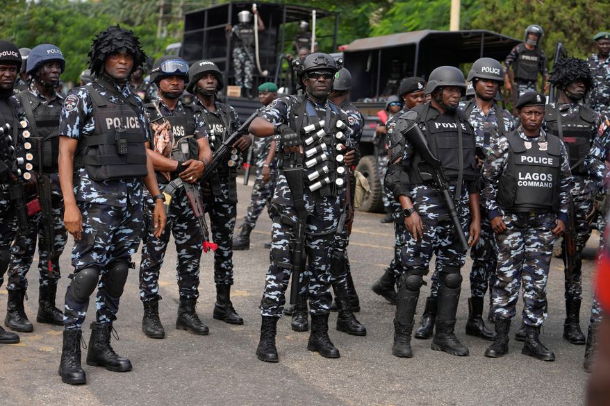 FILE - Nigeria police officers stand guard during a candle light procession in honour of all protesters killed nationwide at the recently economic hardship protest, in Lagos, Nigeria, Friday, Aug. 9, 2024. (AP Photo/Sunday Alamba, file)