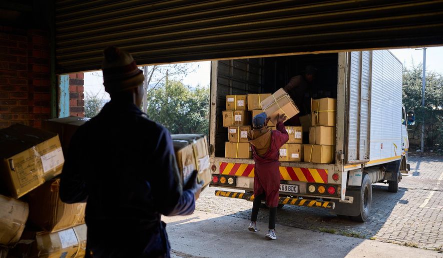 FILE - Workers load a truck with the last boxes filled with clothes from the empty Tzicc clothing factory following the threat of U.S.-imposed tariffs in Maseru, Lesotho, July 22, 2025. (AP Photo/Bram Janssen, File)