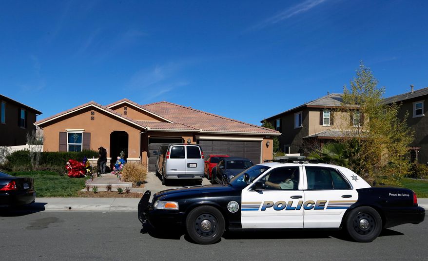 A police car drives past the home of David and Louise Turpin, where police arrested the couple accused of holding their foster children captive, on Jan. 24, 2018, in Perris, Calif. (AP Photo/Damian Dovarganes, File)