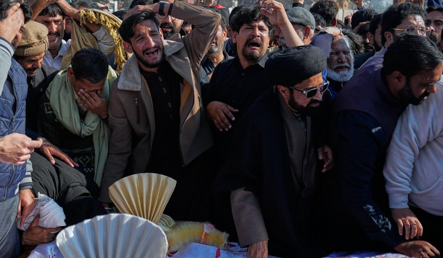 People mourn next the coffin of their relatives, who were killed in Friday's suicide bombing inside a Shiite mosque, in Islamabad, Pakistan, Saturday, Feb. 7, 2026. (AP Photo/Anjum Naveed)