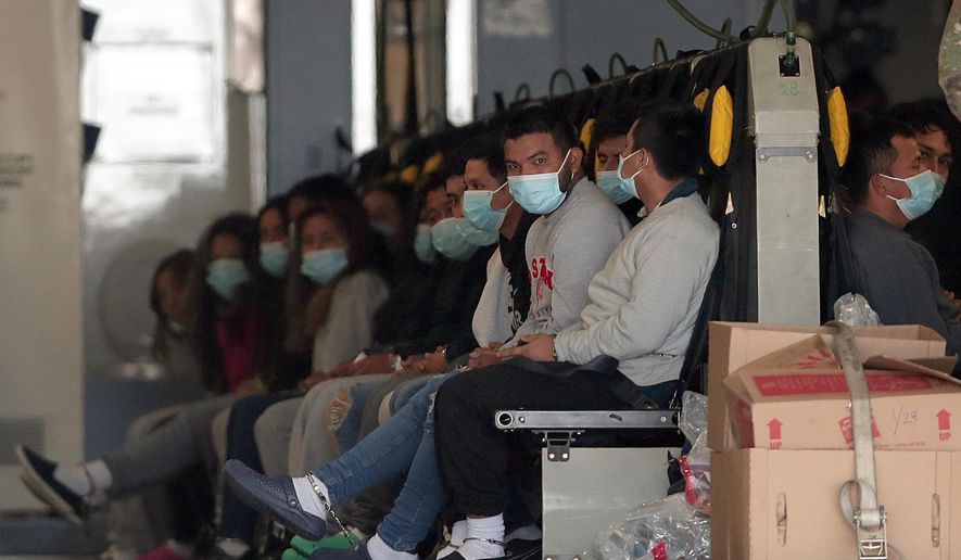 Migrants wearing face masks and shackles on their hands and feet sit on a military aircraft at Fort Bliss in El Paso, Texas, Jan. 30, 2025, awaiting their deportation to Guatemala. (AP Photo/Christian Chavez, File)