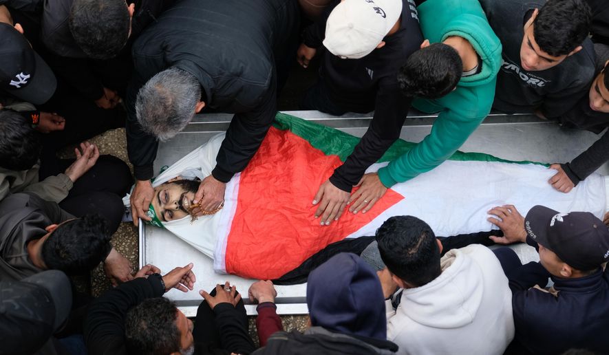 Palestinians mourn over the flag-draped body of a Hamas militant Ibrahim Al-Za'anin, killed in an Israeli army strike, during his funeral in Gaza City, Tuesday, Feb. 10, 2026. (AP Photo/Jehad Alshrafi)