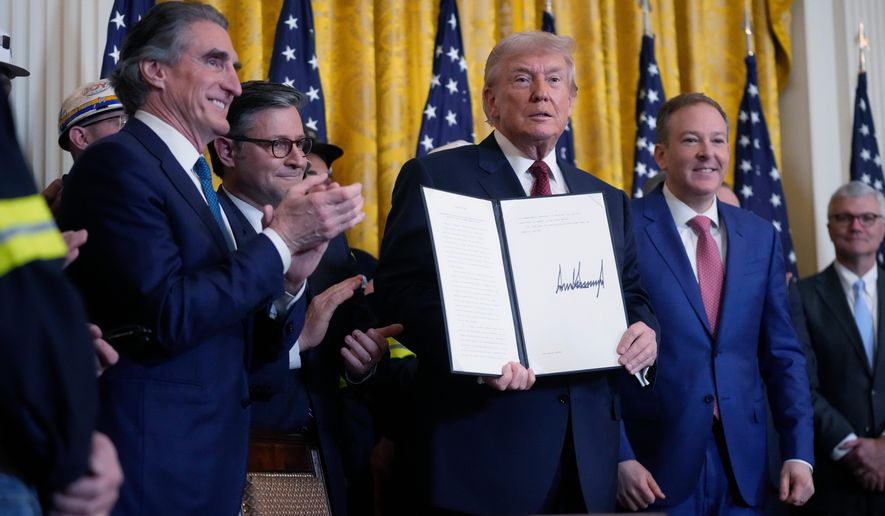 President Donald Trump holds up an executive order he just signed during an event on coal power in the East Room at the White House, Wednesday, Feb. 11, 2026, in Washington. Looking on at right is EPA Administrator Lee Zeldin, House Speaker Mike Johnson, center, and Interior Secretary Doug Burgum at left. (AP Photo/Mark Schiefelbein) **FILE**