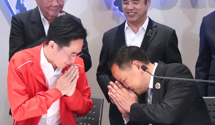 In this photo released by Bhumjaithai Party, Pheu Thai Party prime minister candidate Yodchanan Wongsawat, left, greets Thailand's Prime Minister and leader of Bhumjaithai Party Anutin Charnvirakul at Bhumjaithai, the party headquarters in Bangkok, Thailand, Friday, Feb. 13, 2026. (Bhumjaithai Party via AP)