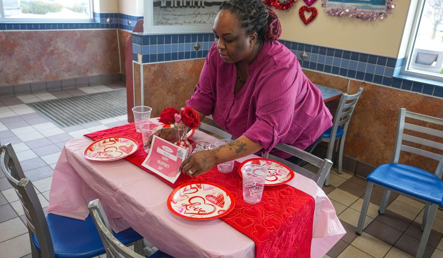 White Castle store manager Alisha Porter sets up a sample table that will be used for the store's Valentine's Day celebration in Indianapolis, Thursday, Feb. 12, 2026. (AP Photo/Michael Conroy)