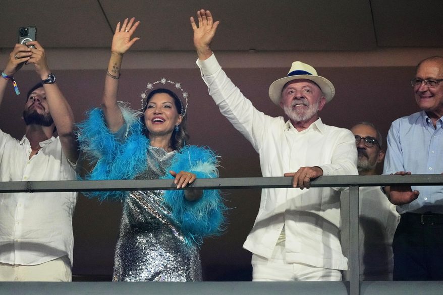 Brazilian President Luiz Inacio Lula da Silva, right, attends the Academicos de Niteroi samba school parade in his honor with first lady Rosangela da Silva at the Sambadrome, in Rio de Janeiro, Sunday, Feb. 15, 2026. (AP Photo/Silvia Izquierdo)