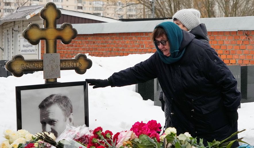 Late Russian opposition leader Alexei Navalny's mother Lyudmila Navalnaya touches his portrait at his grave, two years after his death, at the Borisovskoye Cemetery in Moscow, on Monday, Feb. 16, 2026. (AP Photo/Alexander Zemlianichenko)