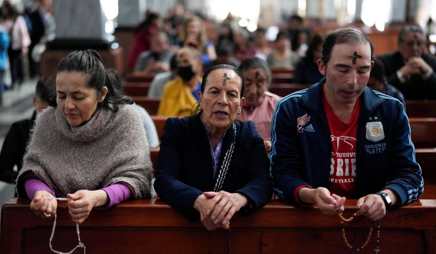 Catholics pray the rosary while a priest marks people's foreheads with ashes during Ash Wednesday Mass at the Church of the Divine Child in Bogota, Colombia, Wednesday, Feb. 14, 2024. (AP Photo/Fernando Vergara, File)
